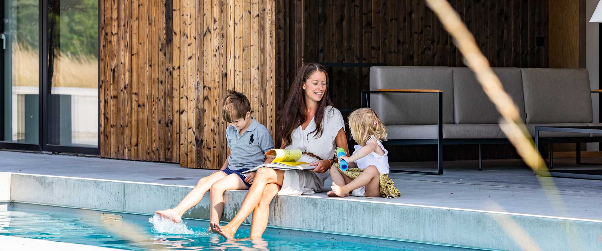Mutter mit zwei Kindern im Sommer am Pool