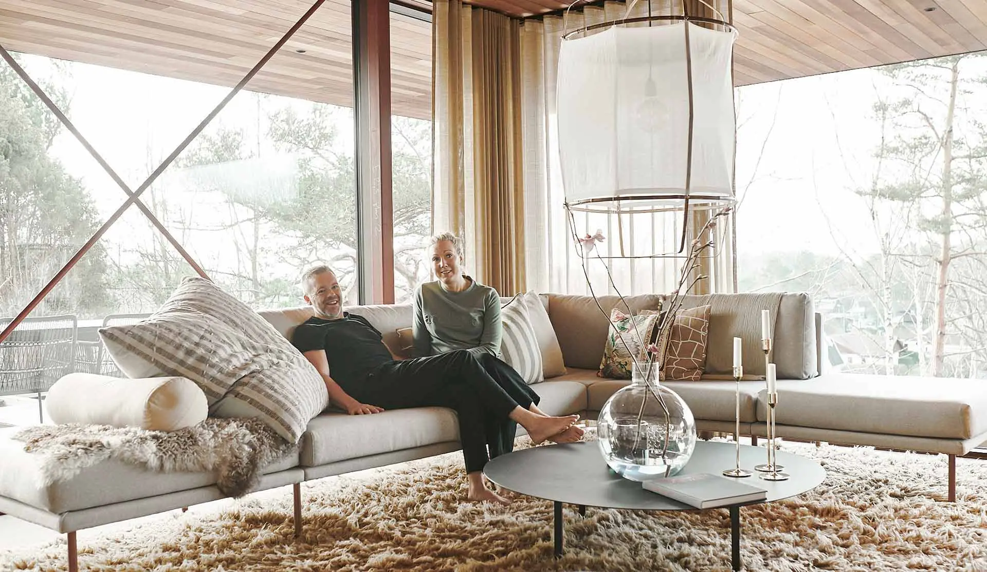 Man and women sits in a couch in a livingroom.  