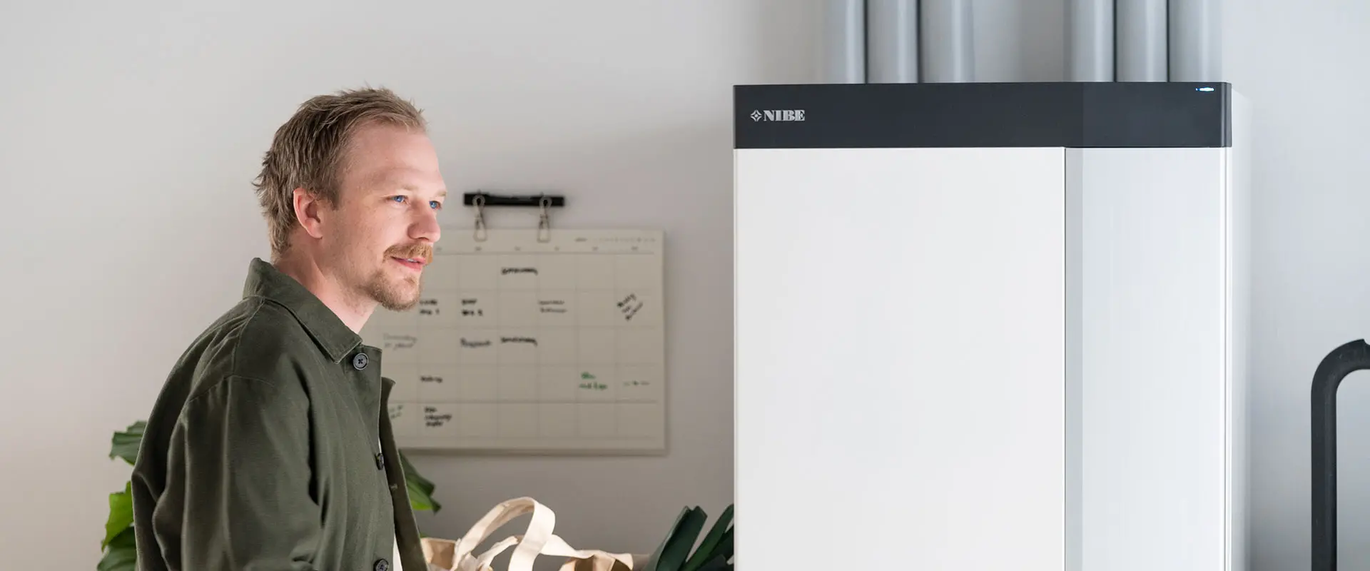 Man next to NIBE Heat Pump