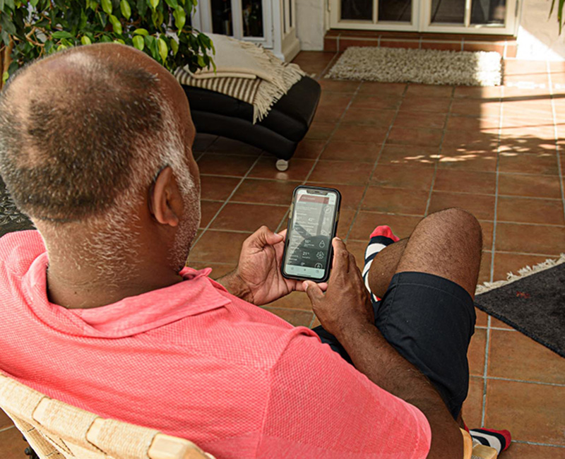 Mårten sitter i soffa med telefon