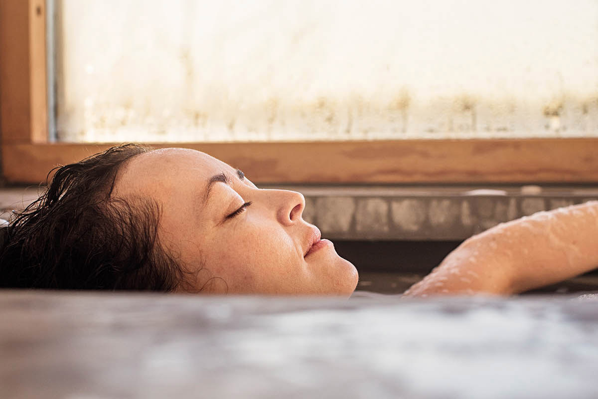 Mädchen hält die Hände in warmes Wasser