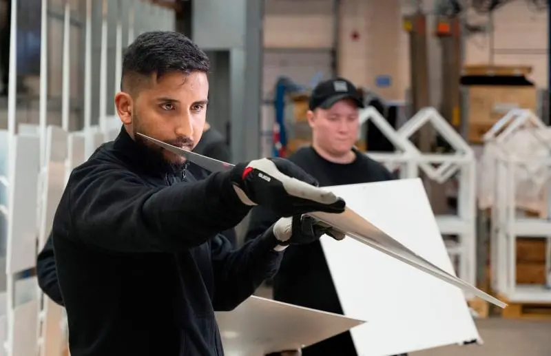 Man holding sheet metal with eyes forward