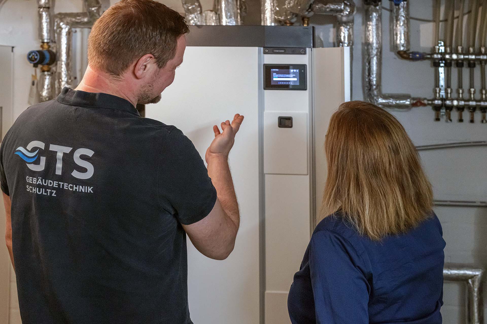 Hausbesitzer und Installateur vor der Inneneinheit