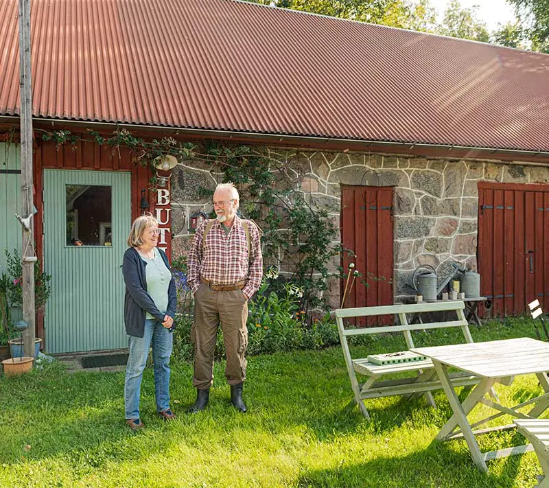 Ulla och Thomas Andersson står utanför sin gårdsbutik en solig sommardag
