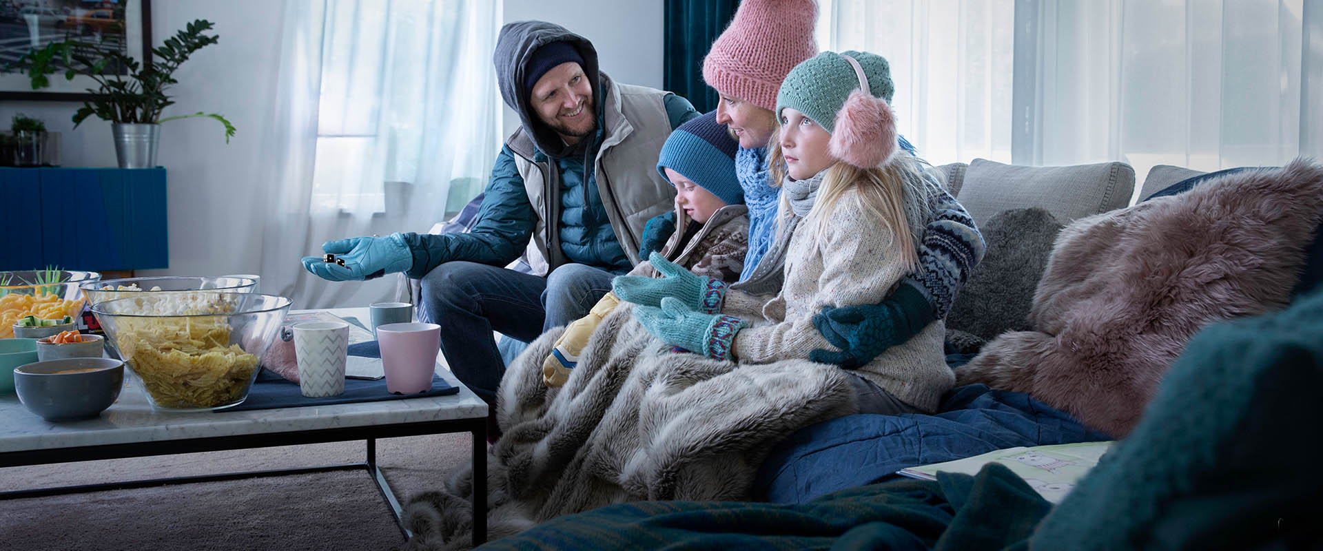 Familie im Wohnzimmer mit Winterkleidung