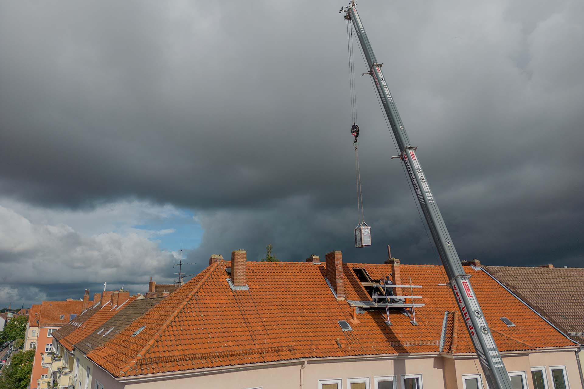 Kran bringt Wärmepumpe zur Dachöffnung