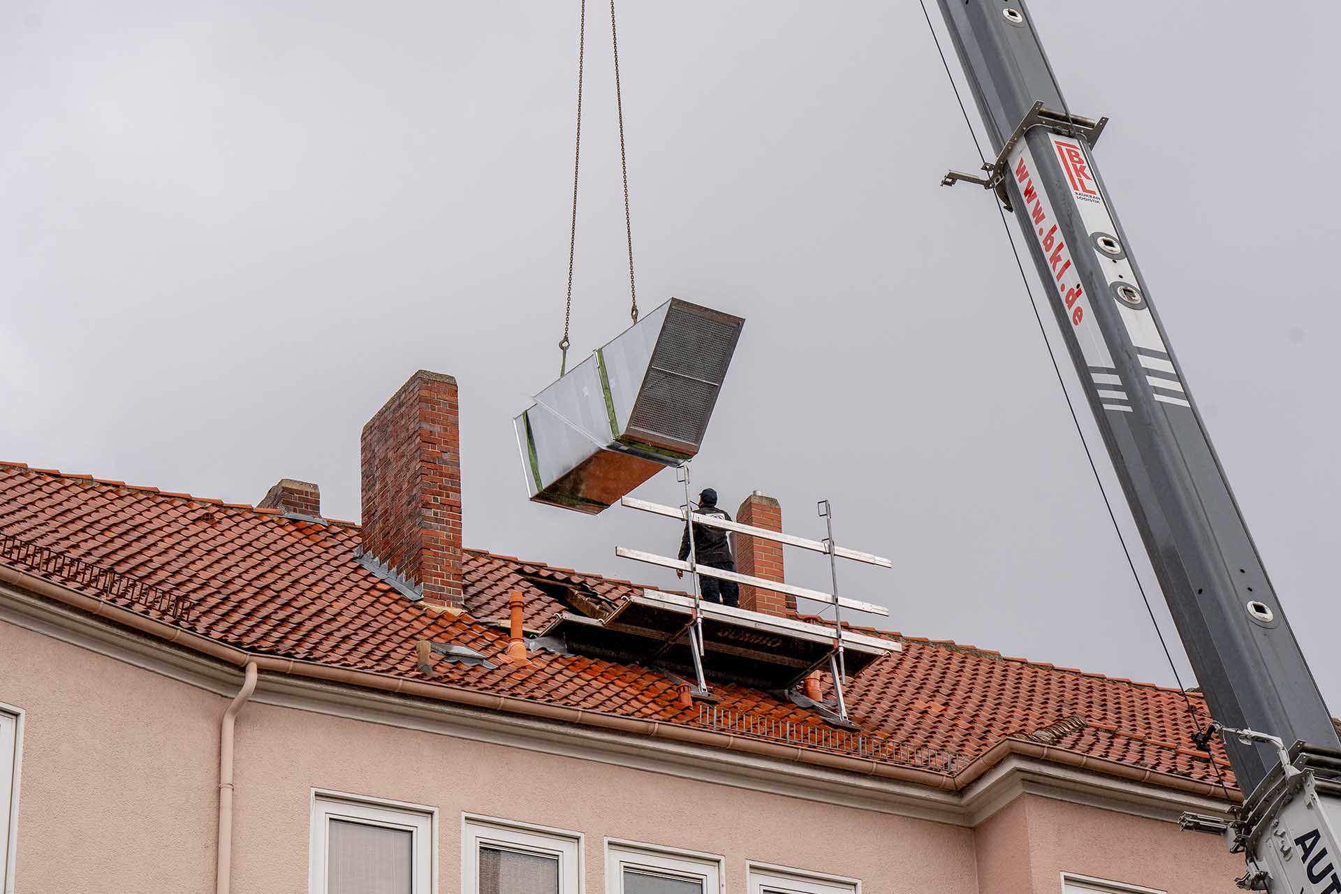 Lüftungskanal wird durch Kran aufs Dach gebracht