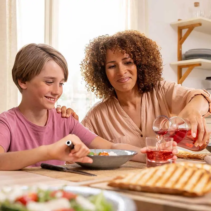 En familie rundt middagsbordet. Rommet er varmet opp av NIBE varmepumpe