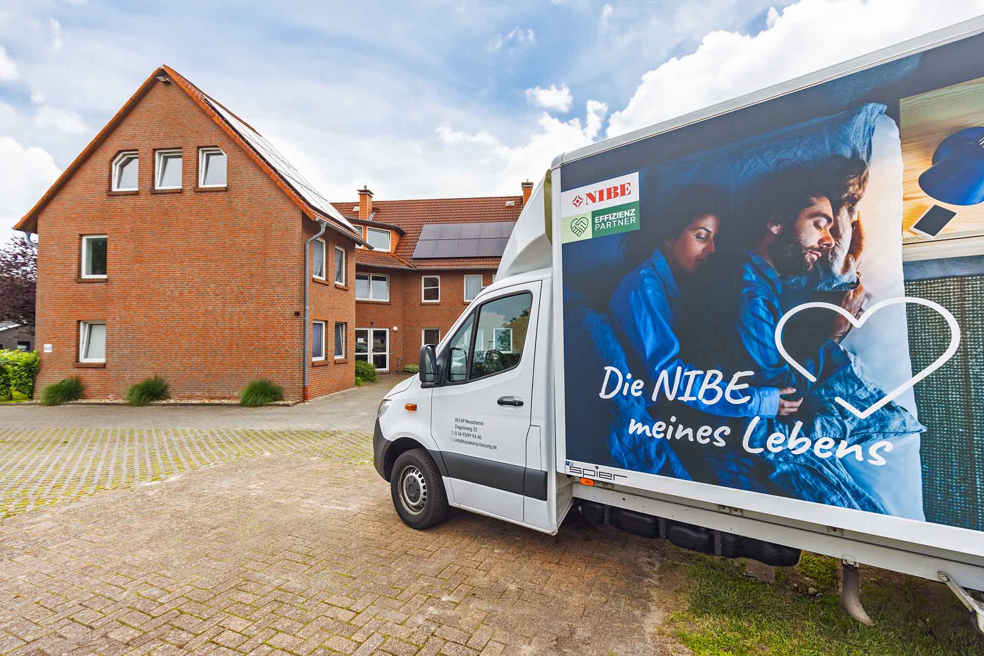 Firmenfahrzeug vor dem Mehrfamilienhaus