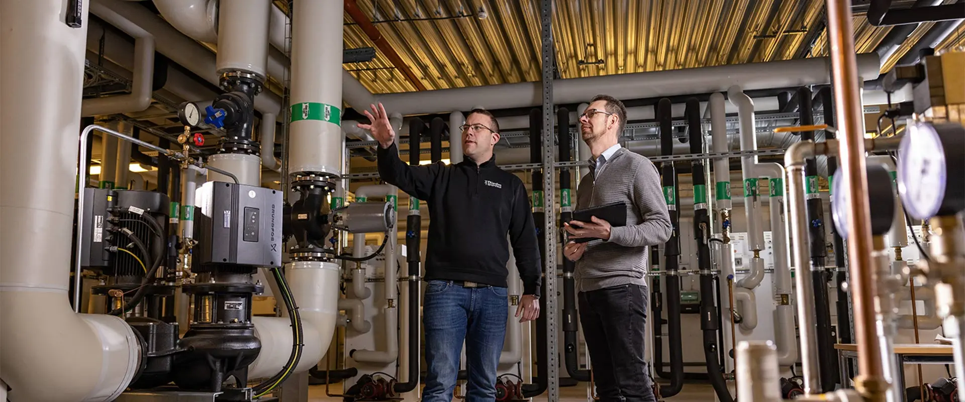 NIBE Klimatlösningar. två män diskuterar en lösning för en större fastighet, Miljöbild